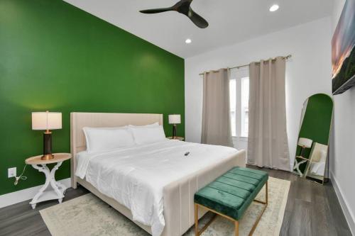 een groene slaapkamer met een bed en een groene muur bij NEW! Luxury Escape: 3BR Oasis in Houston