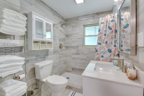 a white bathroom with a toilet and a sink at Emerald Coast Getaway Near Boardwalk and Breweries! in Fort Walton Beach