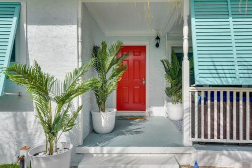 a red door on a house with palm trees at Emerald Coast Getaway Near Boardwalk and Breweries! in Fort Walton Beach
