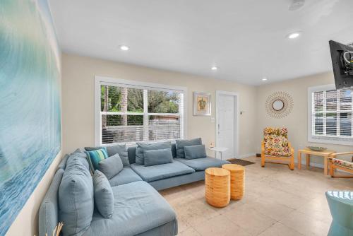 a living room with a blue couch and a table at Grove Bay Bungalow - 2/2 Gated Cottage-Walk to Bay in Miami