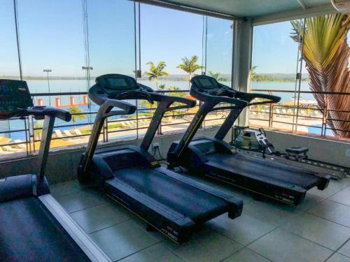 a gym with two treadmills in front of a window at Belo Flat Resort Lake Side Beira Lago in Brasília