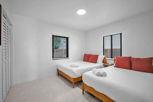 Zimmer mit 2 Betten, einem Sofa und Fenstern in der Unterkunft Villa Roads Family Home 2 Beds 1 Bath in Miami