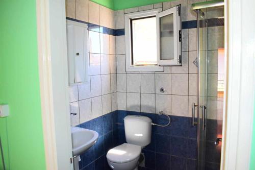 La salle de bains est pourvue de toilettes, d'un lavabo et d'un miroir. dans l'établissement Ostriche House, à Pentátion