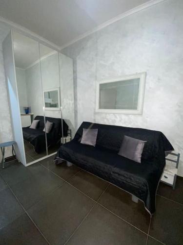 1 dormitorio con cama negra y espejo en CS LUXURY HOUSE 2.0, en Lido di Ostia