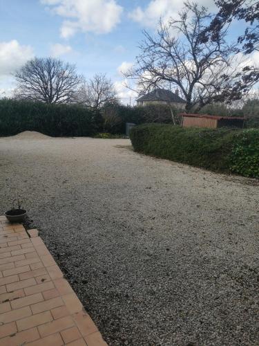 une allée en gravier avec une haie et un arbre dans l'établissement Studio à la campagne, à Champagné-Saint-Hilaire