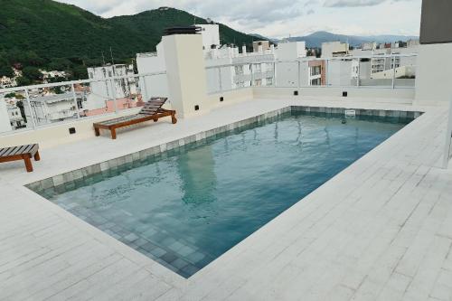 a swimming pool on the roof of a building at Alcazar Suites Deluxe in Salta