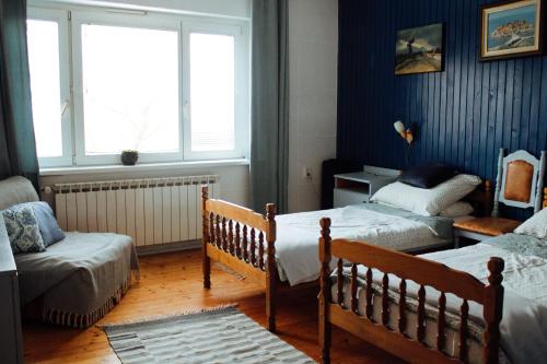 1 dormitorio con 2 camas y ventana en Apartment Hiža 38 en Mala Subotica
