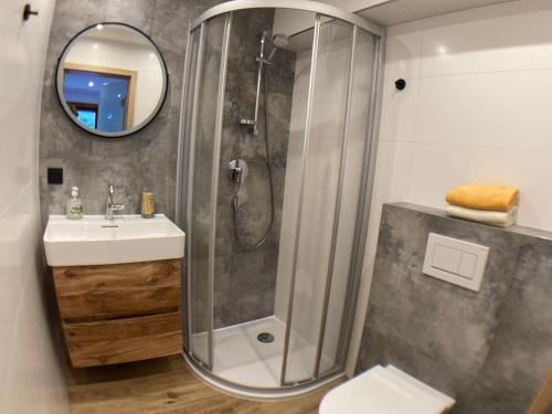 y baño con ducha, lavabo y espejo. en Haus Standlgut Rauris, en Rauris