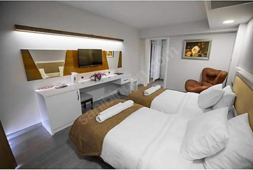 a hotel room with two beds and a desk at GÜNTURPARK OTEL in Beylerbeyi