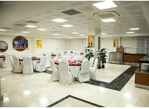 a conference room with a table and white chairs at GÜNTURPARK OTEL in Beylerbeyi