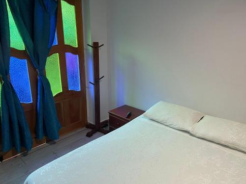um quarto com uma cama e uma janela em Habitación La Amelia em Jericó