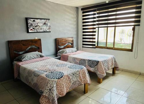 a bedroom with two beds and a window at Casa milito bonito in Morelia
