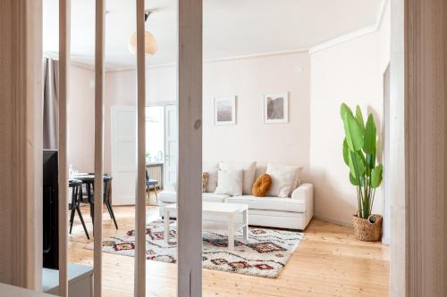een woonkamer met een witte bank en een tafel bij 2ndhomes Bright 125m2 4BR City Center Apartment with the Great Views in Helsinki