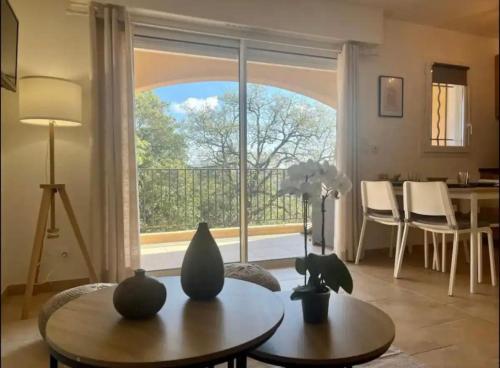 un salon avec une table et une grande fenêtre dans l'établissement DOMAINE LOU BEL AZUR - Charmant, à Saint-Laurent-du-Var