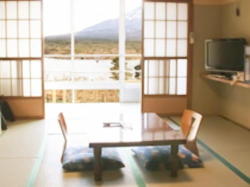 a living room with a table and chairs and a window at Shoji Mount Hotel - Vacation STAY 83015v in Narusawa