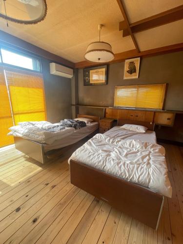 two beds in a room with wooden floors at art village - Vacation STAY 16315v in Awa