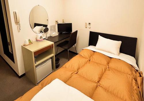 a bedroom with a bed and a desk with a mirror at Hotel MitsuWakan - Vacation STAY 15763v in Tsushima