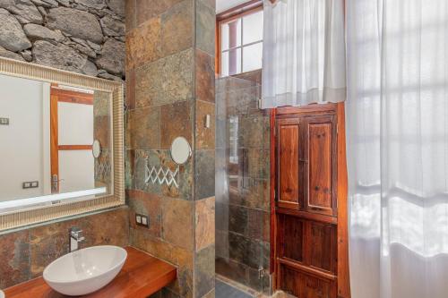 une salle de bain avec un lavabo et un miroir dans l'établissement Casa Emblemática - Encanto y lujo frente a la playa, à Santa Cruz de la Palma