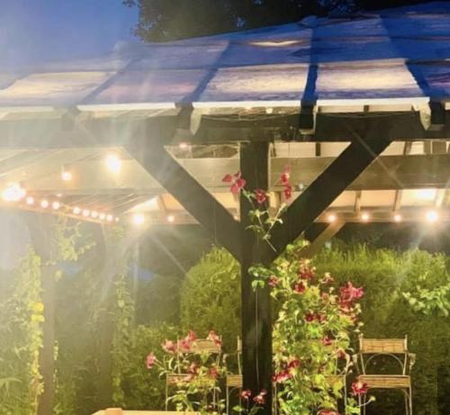 a garden with a pergola and a table with flowers at The Wheatsheaf in Bramley