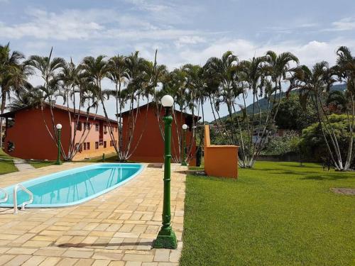 un poste de luz verde junto a una piscina en Apartamento Inteiro – Conforto e paz, en Ilhabela
