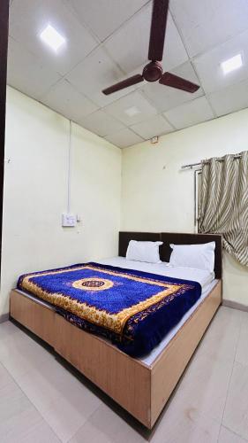 a bed in a room with a ceiling fan at Aashapurti Hotel in Aurangabad