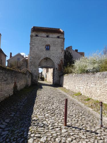 an alley in an old stone building with an archway at La Maison du Prince de Condé in Charroux-dʼAllier