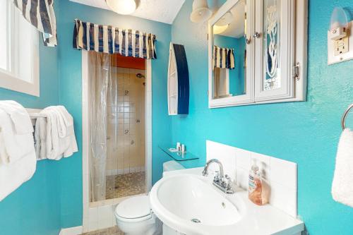 La salle de bains bleue est pourvue d'un lavabo et de toilettes. dans l'établissement Sparkling Sands Oceanfront, à San Marine
