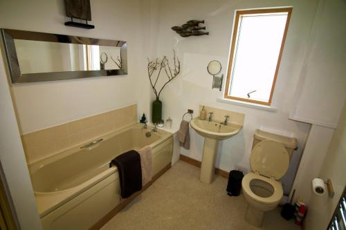 a bathroom with a tub and a toilet and a sink at Rysa House B&B in Stromness