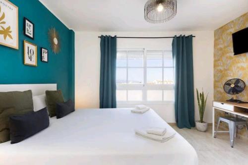a bedroom with a large white bed with blue walls at Ke Casetta Tenerife Emma House with jacuzzi in Callao Salvaje