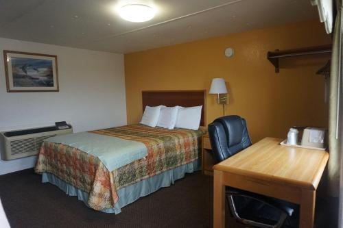 a hotel room with a bed and a desk at Pearsall Executive Inn in Pearsall