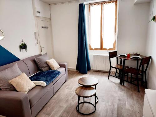 un salon avec un canapé et une table dans l'établissement Studio B aux pieds des Thermes, à Néris-les-Bains