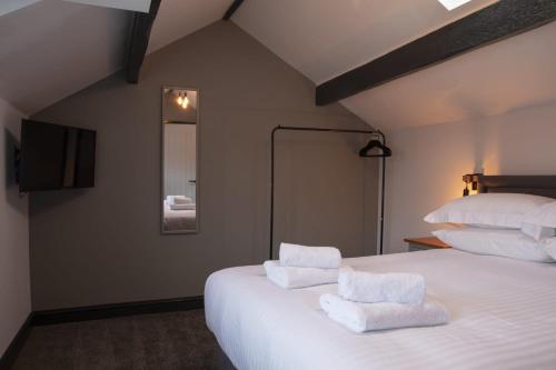 a bedroom with a white bed with towels on it at Botanic Mews in Southport