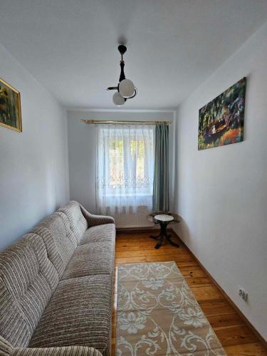 a living room with a couch and a window at Sopot Story in Sopot