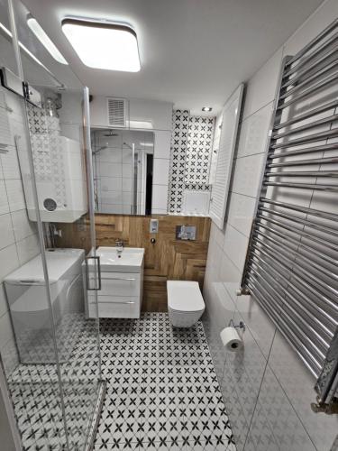 een badkamer met een toilet, een bad en een wastafel bij MieszkanieSopot in Sopot