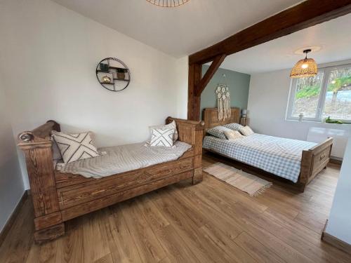 2 camas en una habitación con suelo de madera en le chalet du bonheur, en Liessies