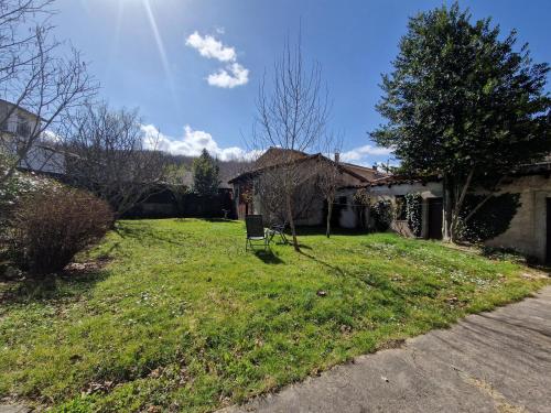 une cour avec une chaise en face d'une maison dans l'établissement Gîte de las Randoletas, à Dreuilhe