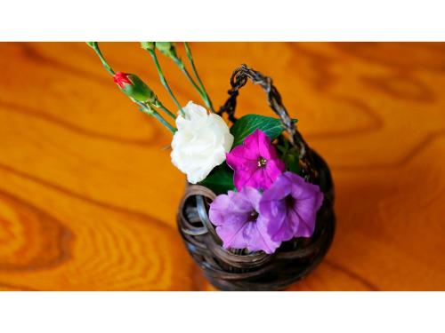 a vase with purple and white flowers in it at Mikuma Hotel - Vacation STAY 63475v in Hita