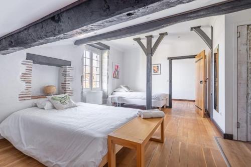une chambre blanche avec un grand lit et une table dans l'établissement Villa de charme avec piscine, à Saint-Étienne-dʼOrthe