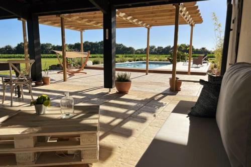 un patio avec une table et une piscine dans l'établissement Villa de charme avec piscine, à Saint-Étienne-dʼOrthe