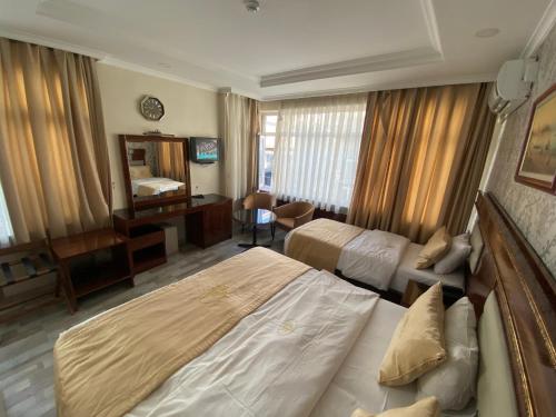 een hotelkamer met 2 bedden en een spiegel bij Elit Palace Hotel in Istanbul