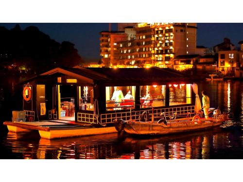 a boat with a restaurant on the water at night at Mikuma Hotel - Vacation STAY 63441v in Hita