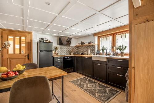 a kitchen with wooden cabinets and a wooden table at Casa Pasch - Boutique Bed and Breakfast in Cumpadials in Sumvitg