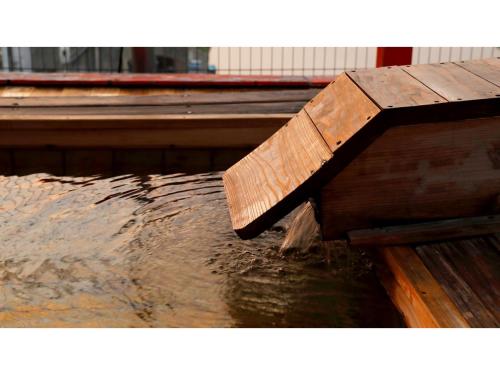 a wooden bench sitting in water next to a dock at Mikuma Hotel - Vacation STAY 63481v in Hita