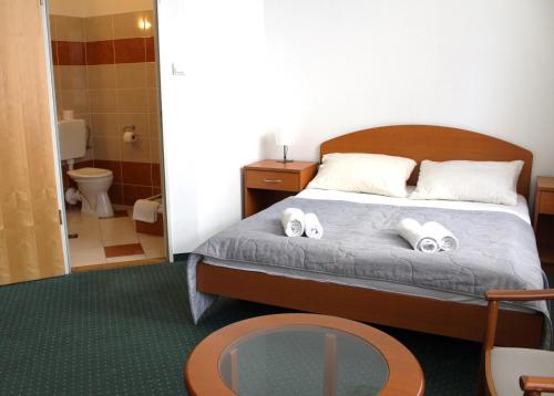 um quarto com uma cama com duas toalhas em Broadway City Guesthouse em Budapeste