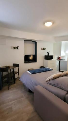 - une chambre avec 2 lits, une table et un miroir dans l'établissement Studio B aux pieds des Thermes, à Néris-les-Bains