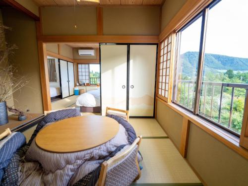 Zimmer mit einem Tisch, Stühlen und Fenstern in der Unterkunft Ashigarashimogun - Glamping - Vacation STAY 75753v in Sengokuhara