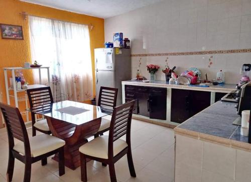 a kitchen with a table and chairs and a refrigerator at Casa milito bonito in Morelia