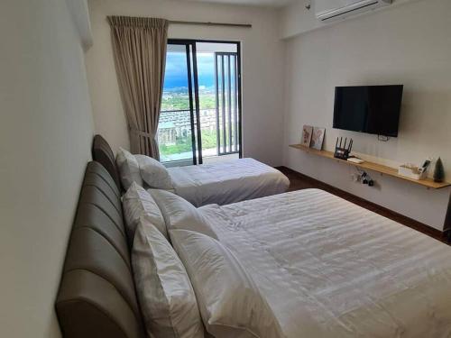 een hotelkamer met 2 bedden en een televisie bij KaMi Homestay (2-3pax)/国际机场5分钟 in Donggongon