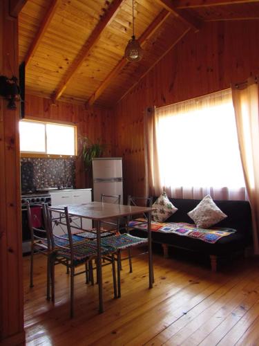 ein Esszimmer mit einem Tisch, Stühlen und einem Sofa in der Unterkunft Cabañas Arrayán in Ancud