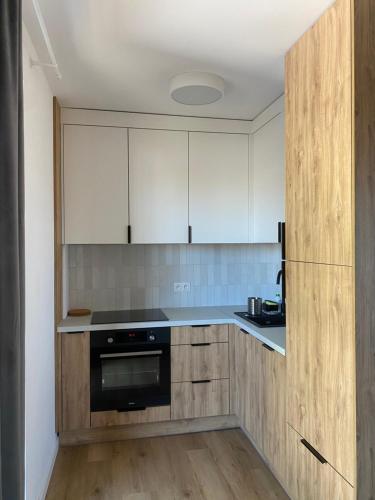 eine Küche mit weißen Schränken und einem schwarzen Backofen in der Unterkunft Apartament Delux - Przytulny Zakątek Karkonoszy in Karpacz